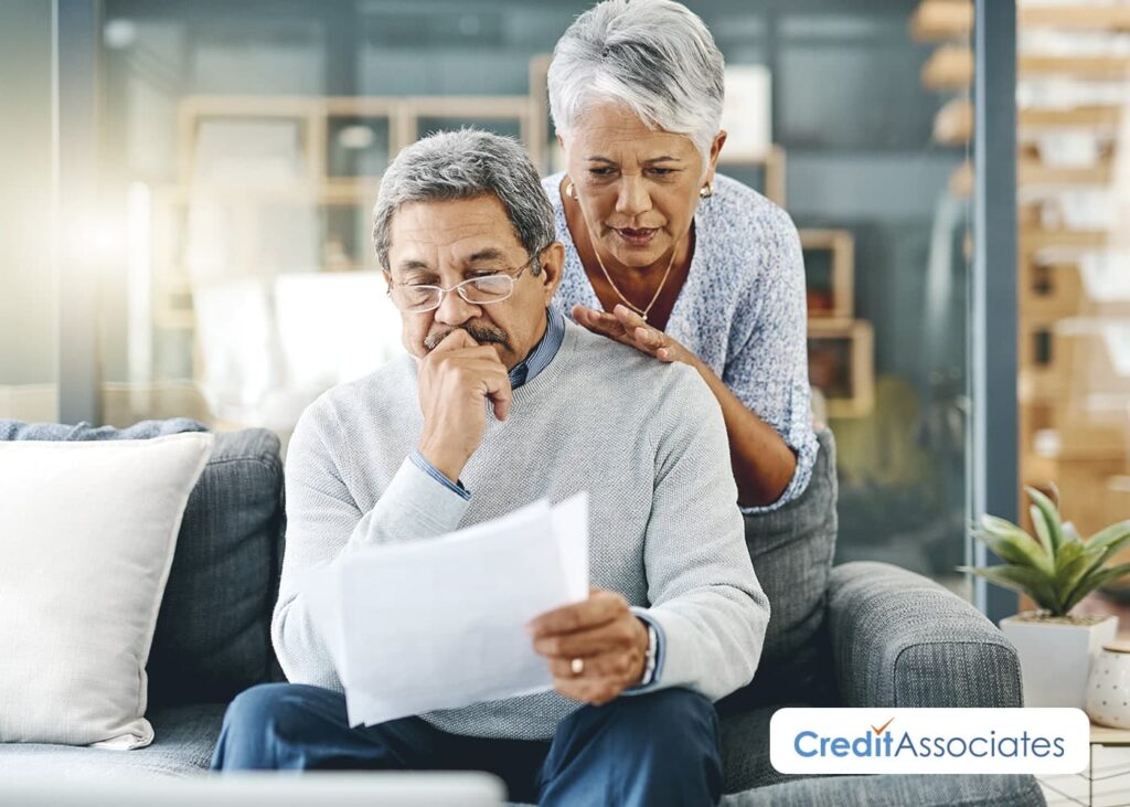 Older man and woman viewing and preparing debts.